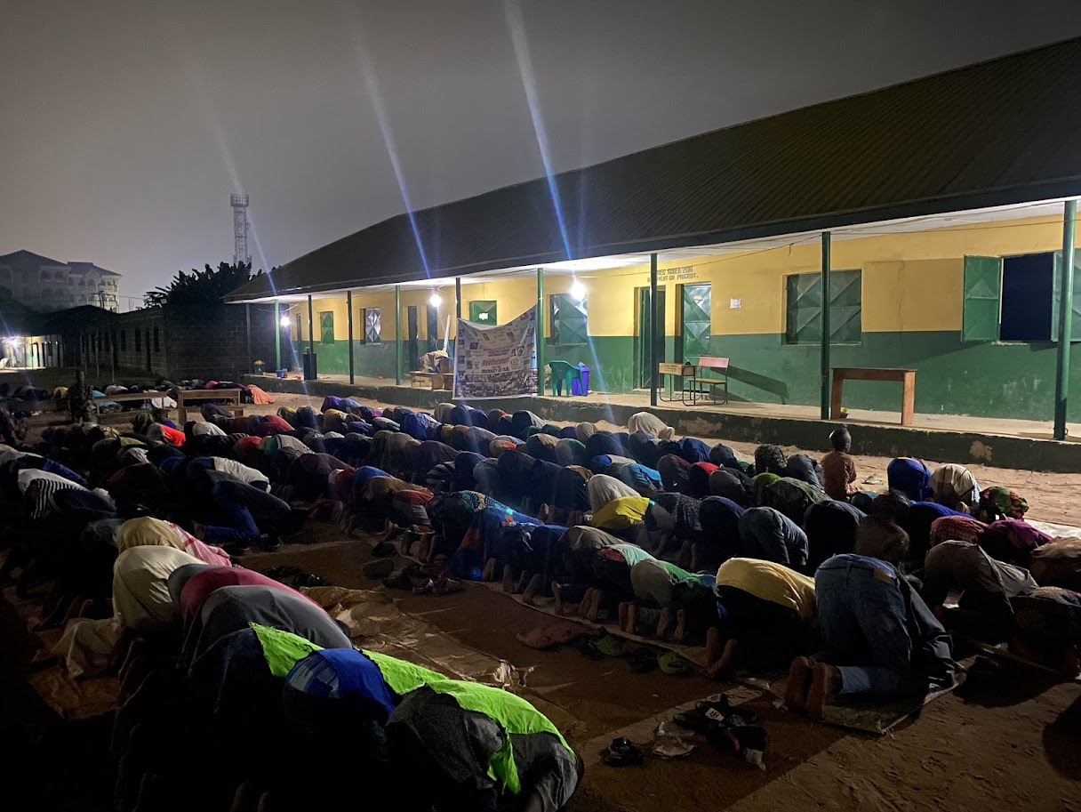 SUDAI Youth Wing members praying together outdoors